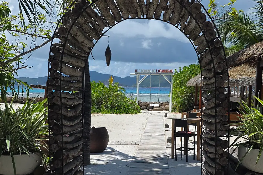 Romantischer Torbogen am Strand von La Digue, Seychellen, idealer Ort für Hochzeiten und unvergessliche Momente.